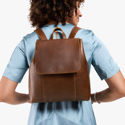 Asheville | Model wearing a leather backpack on a white background