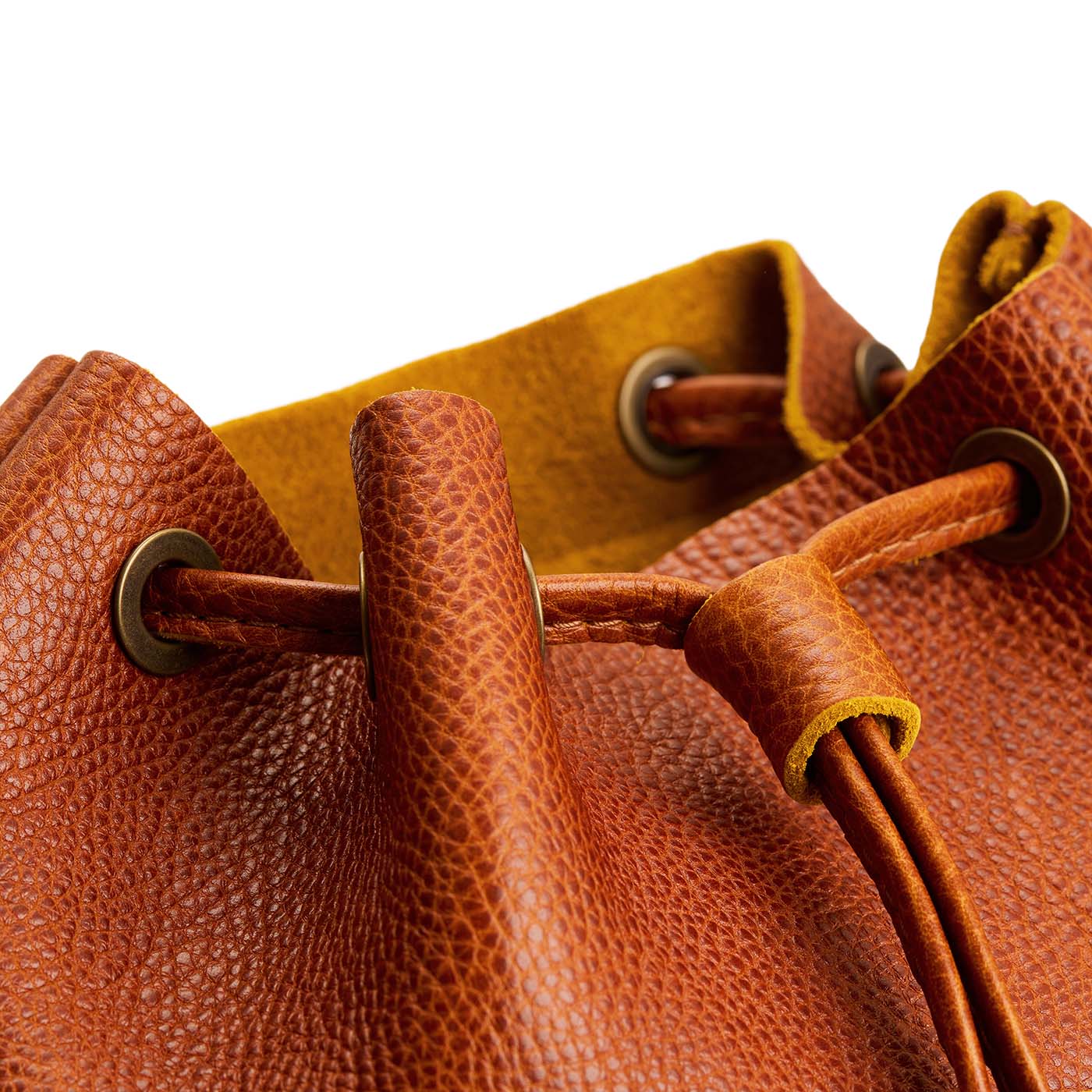 Sienna | Close-up of a leather drawstring backpack with grommets.