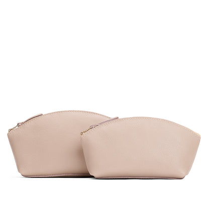 Oatmilk | Size comparison shot of two spacious leather makeup bags with curved seams and top zipper