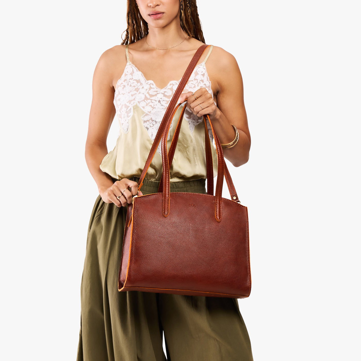 Nutmeg*Large | Model carrying leather tote bag with handles, adjustable crossbody strap, and two back pockets