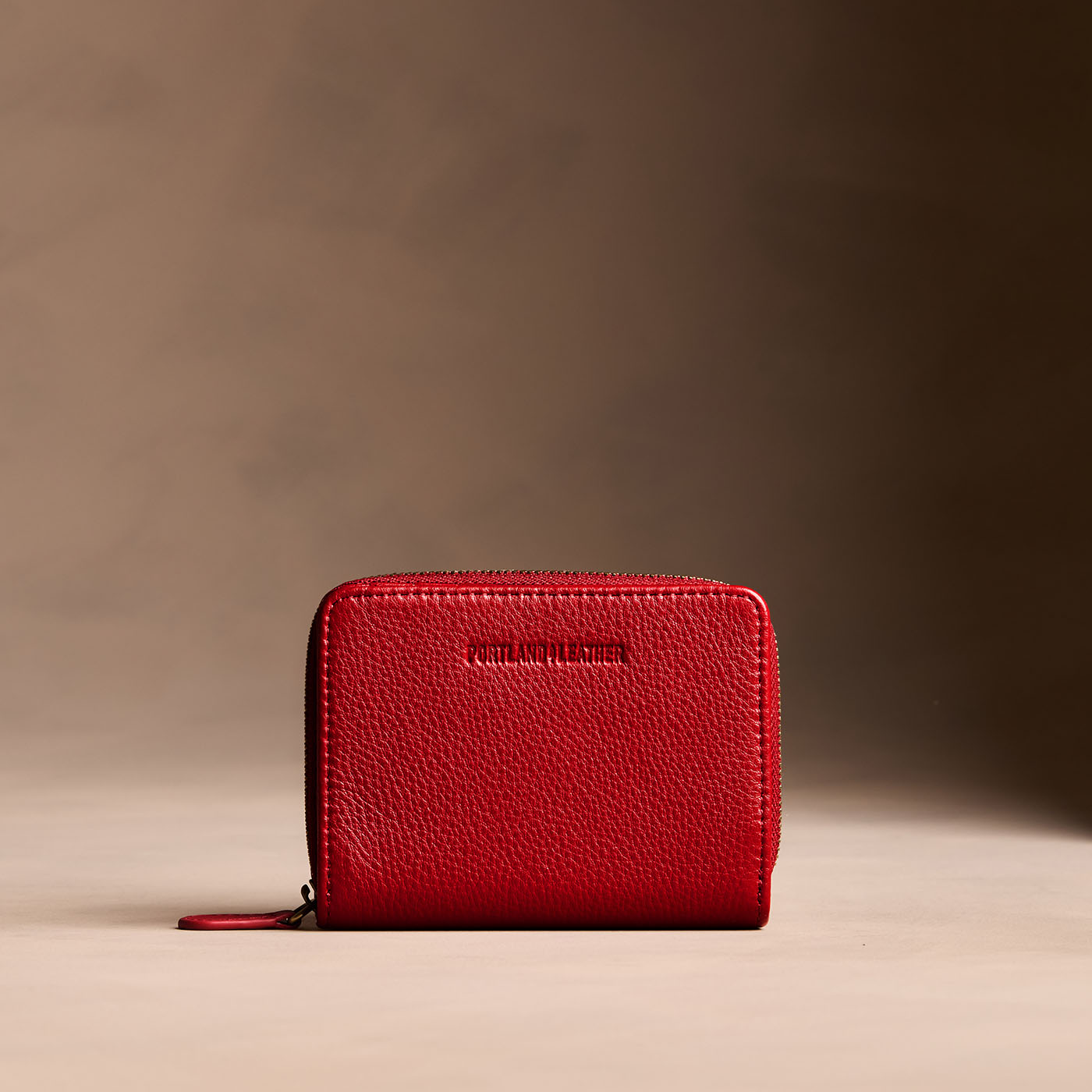 Icon Red | Wallet with card and storage pockets on a light brown background
