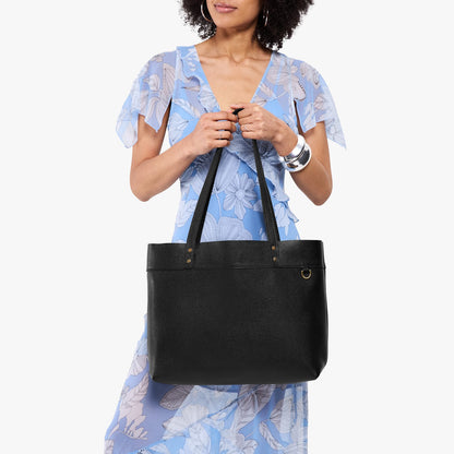 Pebbled--black*Large*Classic | Model wearing leather tote bag with riveted straps and exterior key loop