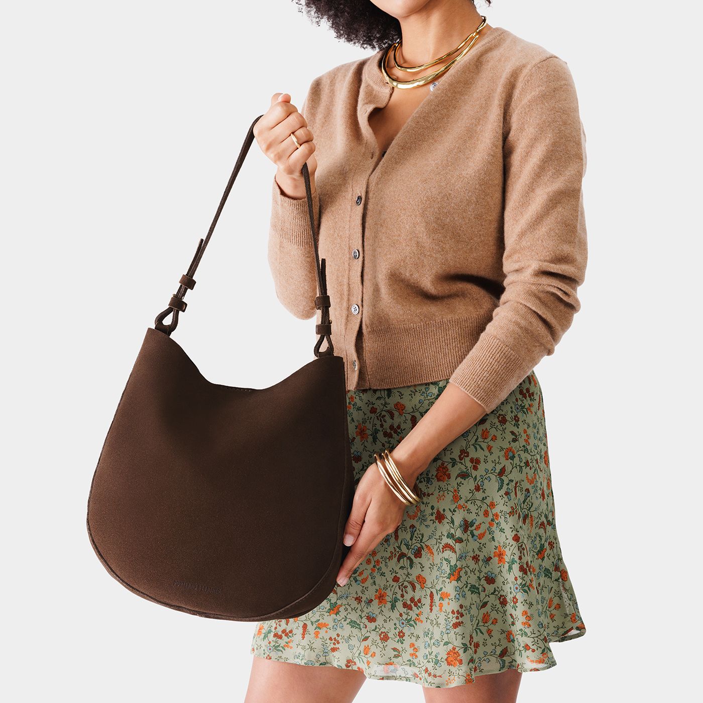 Stagecoach*Large | Woman wearing rounded shoulder bag with adjustable strap on a white background