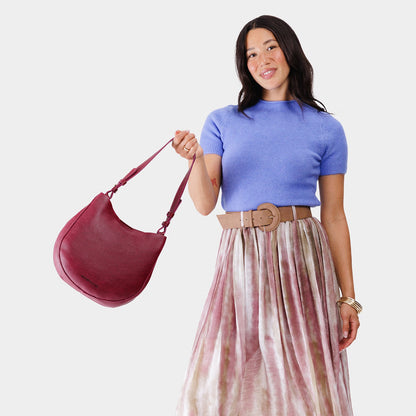 Orchid*Medium | Woman wearing rounded shoulder bag with adjustable strap on a white background