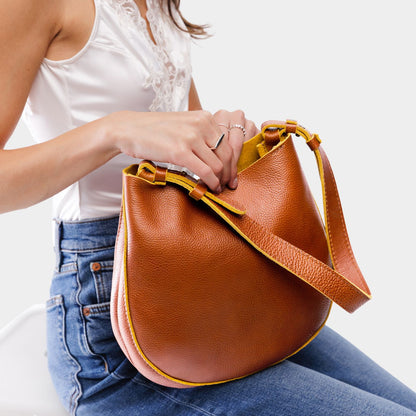 Sienna*Medium | Woman wearing rounded shoulder bag with adjustable strap on a white background