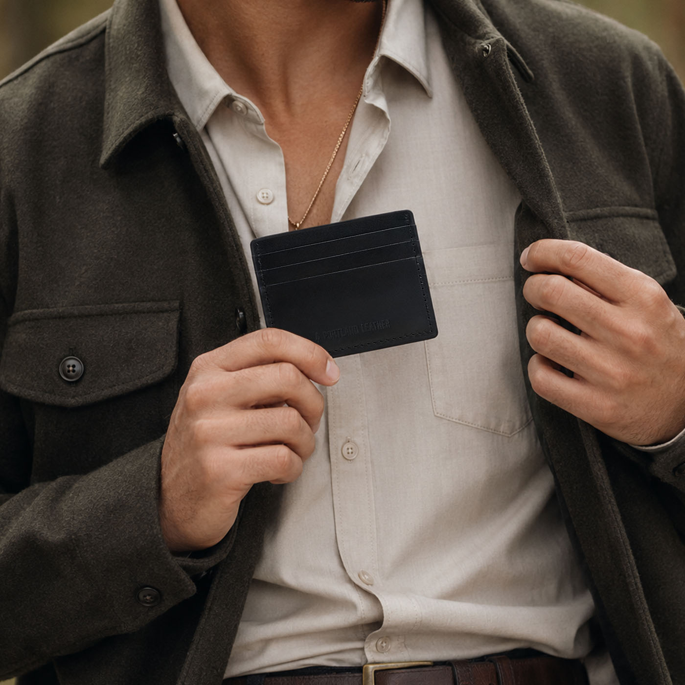 Nero | A close-up lifestyle shot of a model holding a leather card holder