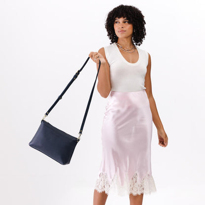 Night Owl*Large | A Model holding a zip top crossbody bag with detachable strap