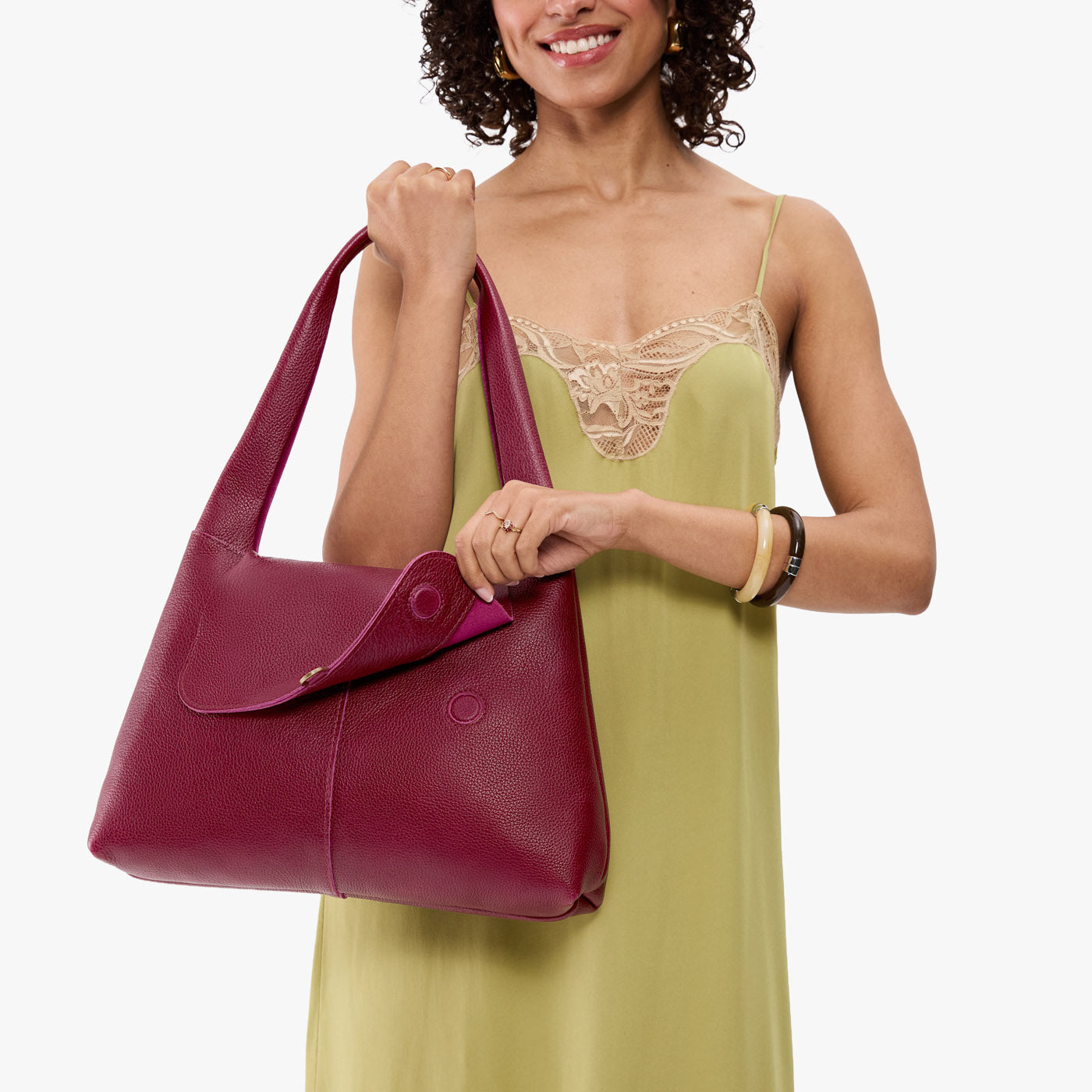 Orchid*Medium | A model holding a slouchy triangle shaped shoulder bag with a flap