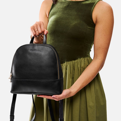 Pebbled--black | Model holding leather backpack with debossed Portland Leather logo on front