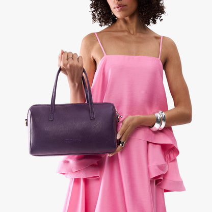 Empire*Oversized | Model holding mini duffle shaped handbag with crossbody strap