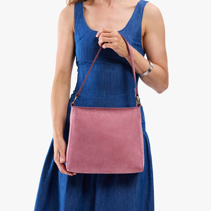 Hollyhock | Model holding a triangular shoulder bag with antiqued brass finished
